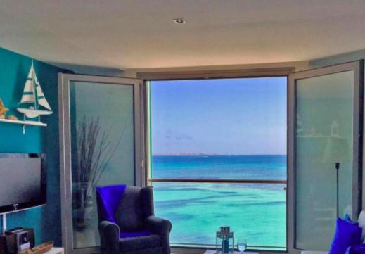 a living room with a view of the ocean at On the Beach in Corralejo