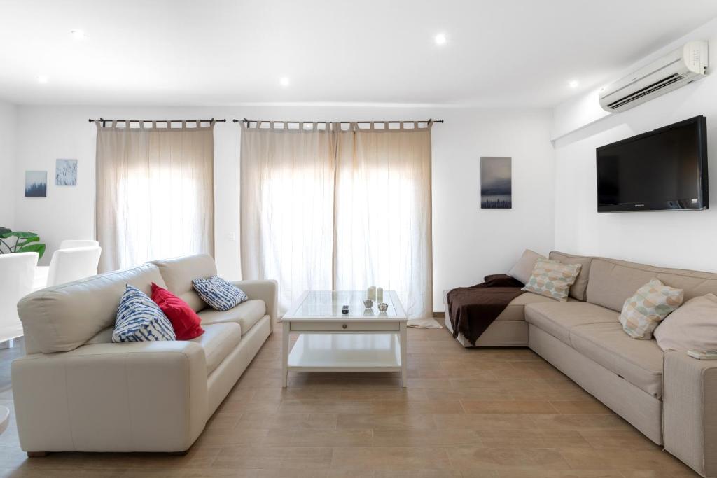 a living room with two couches and a tv at Maka beach apartment v in Castelldefels