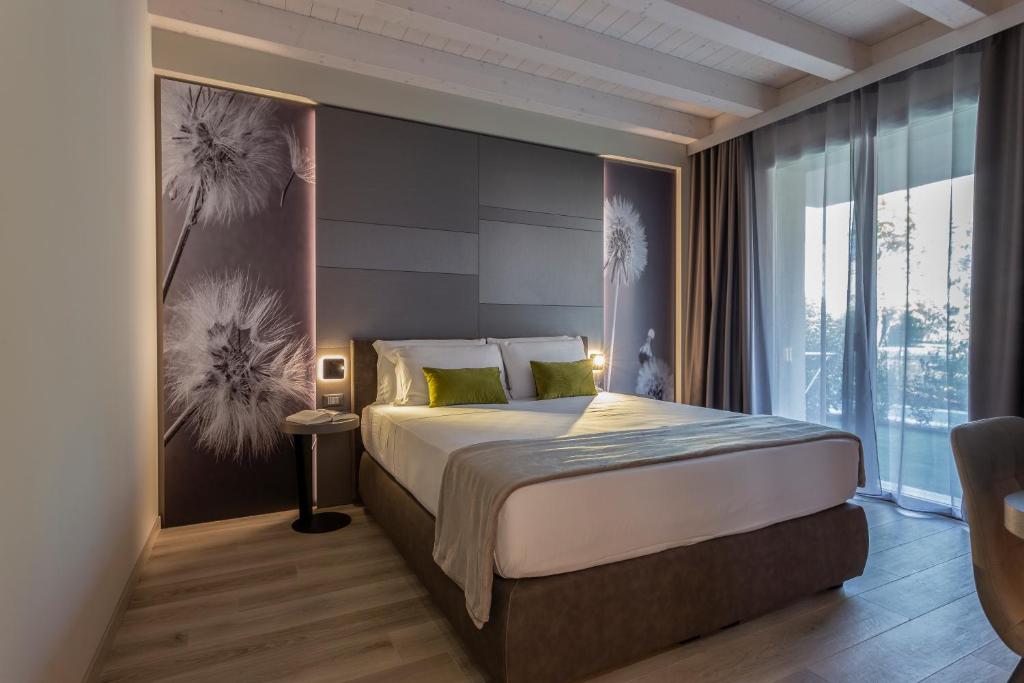 a bedroom with a bed and a large window at PRADA' Home Eco Suites in Bardolino