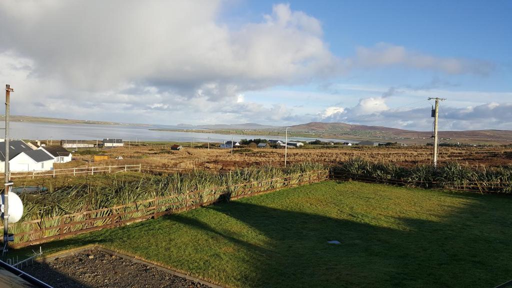 un champ avec une clôture et une masse d'eau dans l'établissement Belmullet View Holiday Accommodation, à Derrynameel