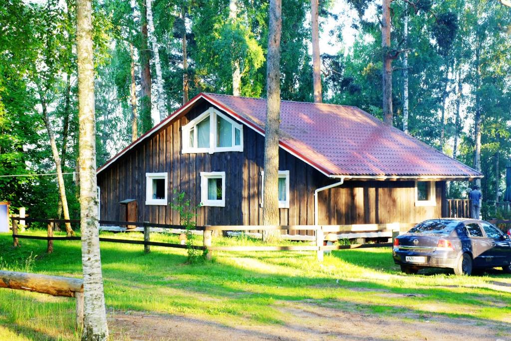 a wooden house with a car parked in front of it at Tihaya Dolina in Kappanen
