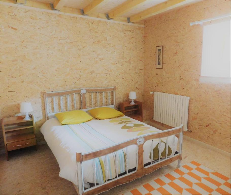 ein Schlafzimmer mit einem Bett mit gelben Kissen darauf in der Unterkunft l'heureux bazar in Saint-Nectaire