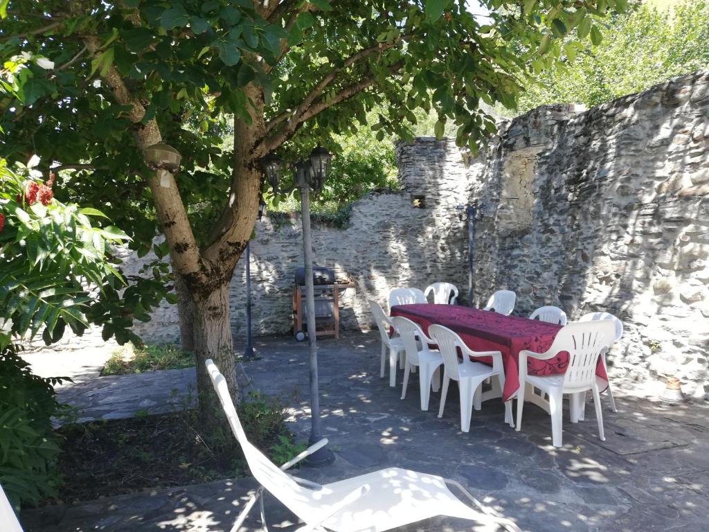 uma mesa e cadeiras debaixo de uma árvore num quintal em Le Pijoulet em Tignac