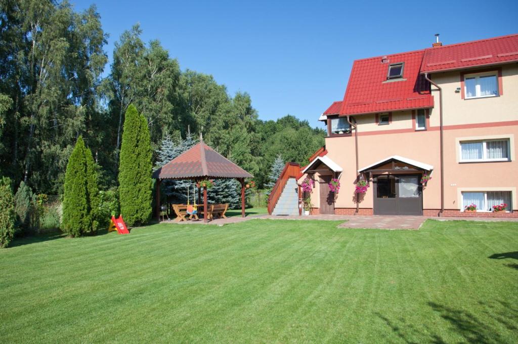 un gran patio con una casa y un cenador en Kryniczanka, en Sztutowo