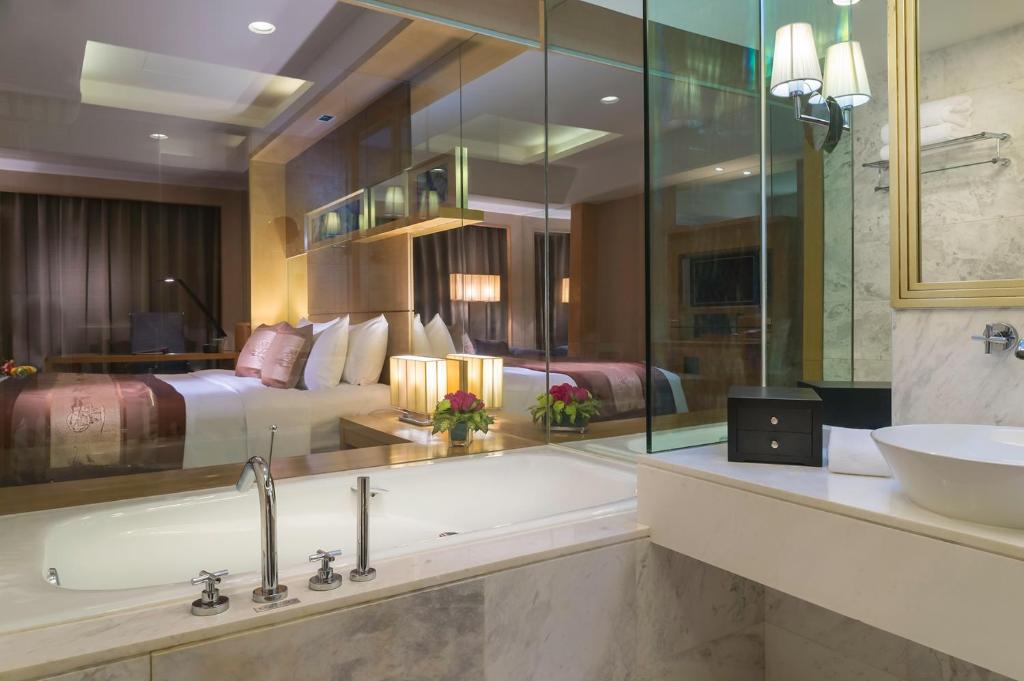 ein Bad mit einer Badewanne, einem Bett und einem Waschbecken in der Unterkunft Wyndham Garden Suzhou in Suzhou