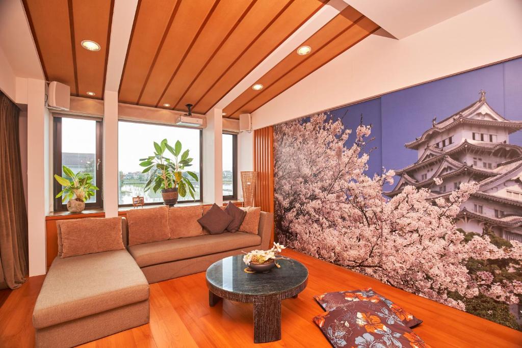 una sala de estar con sofá y una pintura de un edificio en Memory Garden, en Luodong