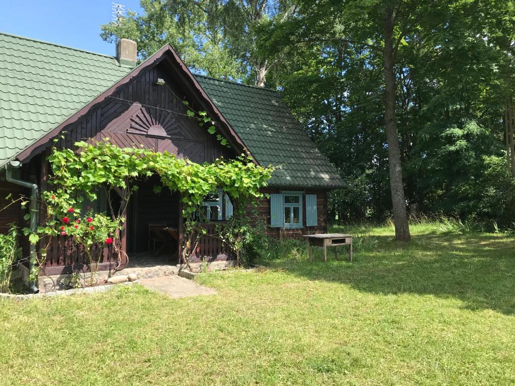 una piccola casa con un mucchio di viti sopra di Suwalskie siedlisko a Szlinokiemie