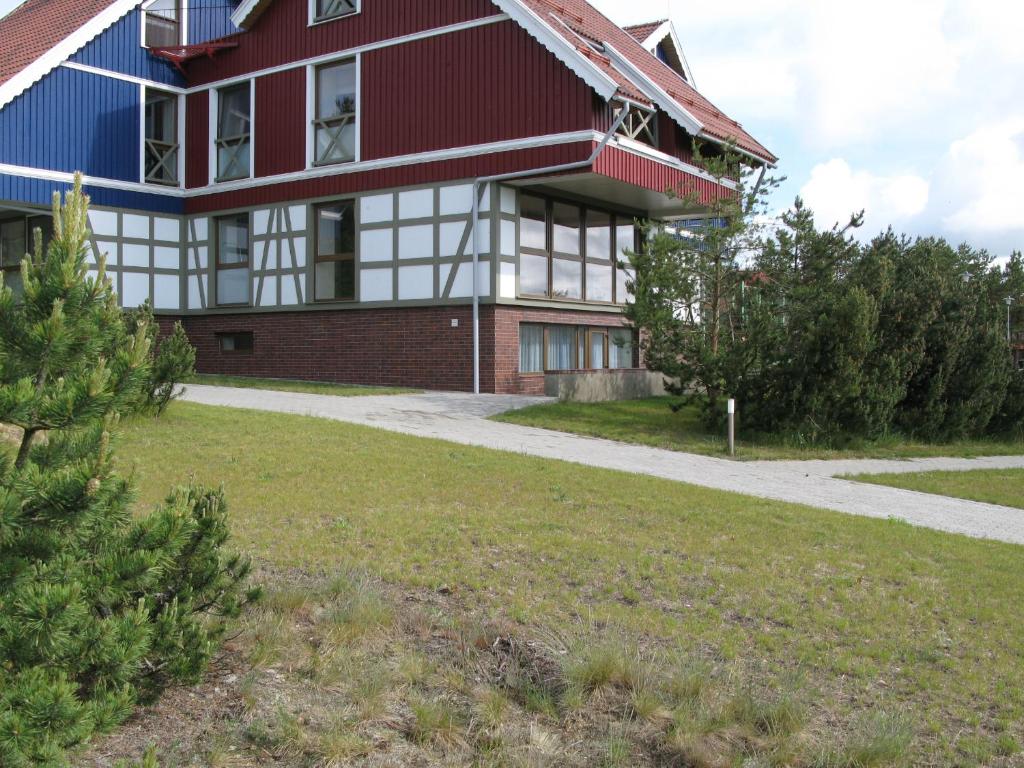 奈達的住宿－尼多斯博依塞內一室公寓，一座红白色房子,有草地庭院