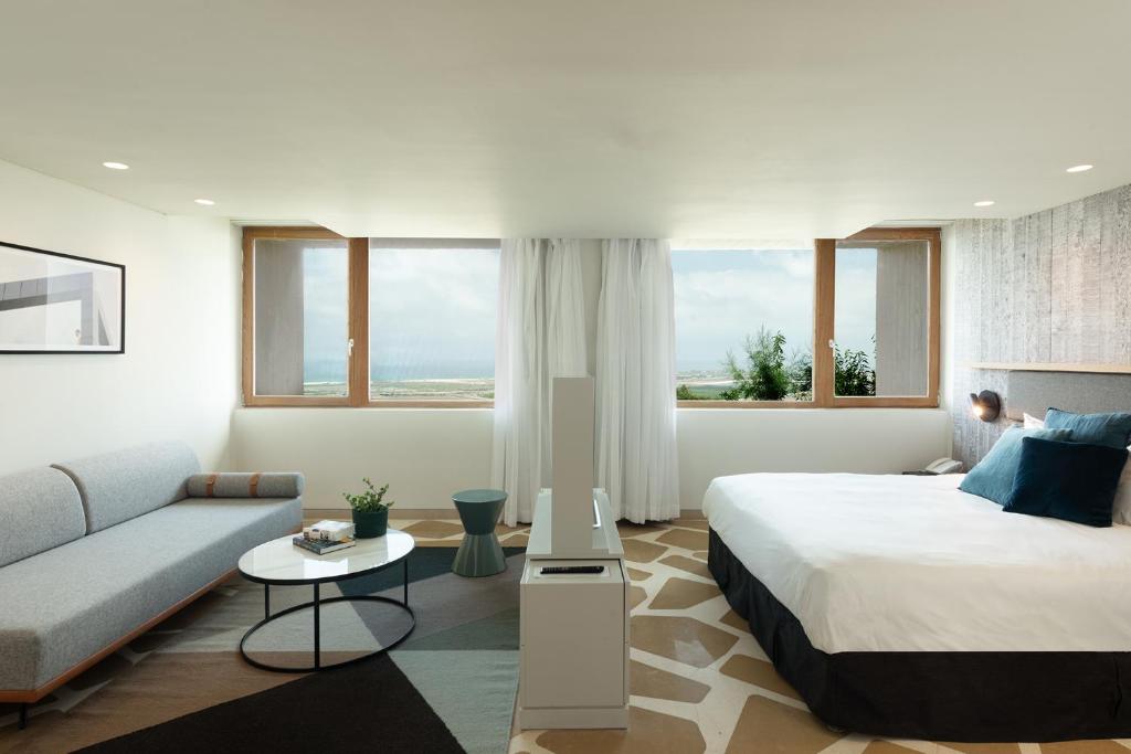 a hotel room with a bed and a couch at Elma Hotel and Art Complex in Zikhron Ya'akov