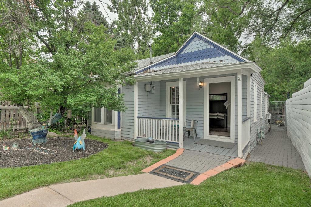 a small blue house with a little girl in the yard at Creekside Home with Patio, Walk to Manitou Incline! in Manitou Springs