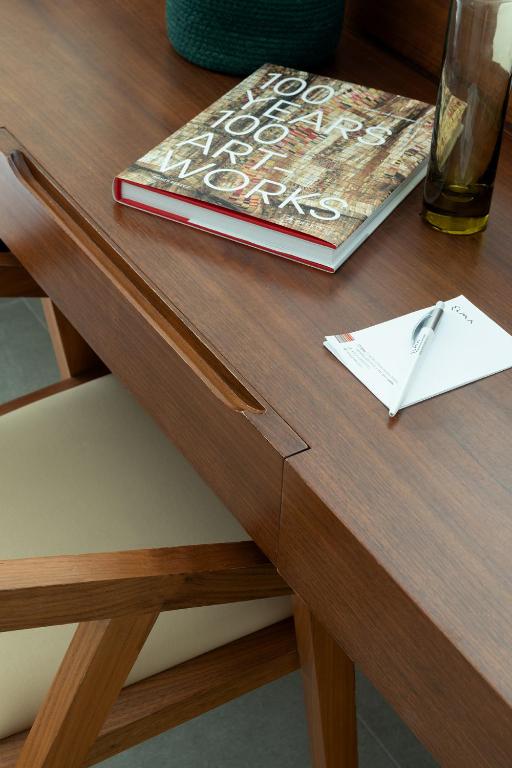 a book and a pen on a wooden table at Elma Hotel and Art Complex in Zikhron Ya'akov