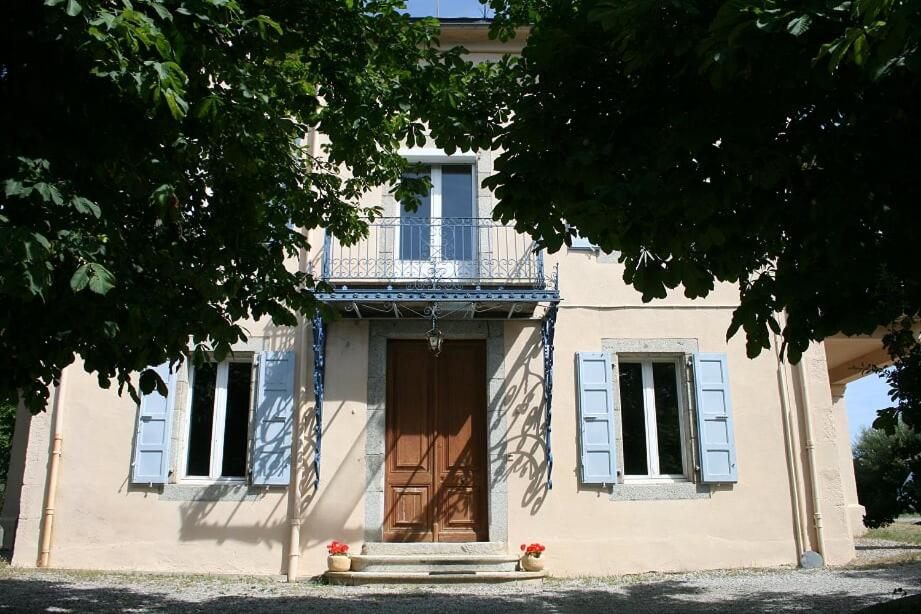 a white house with a balcony and a door at Le petit manoir de Palau in Palau-de-Cerdagne