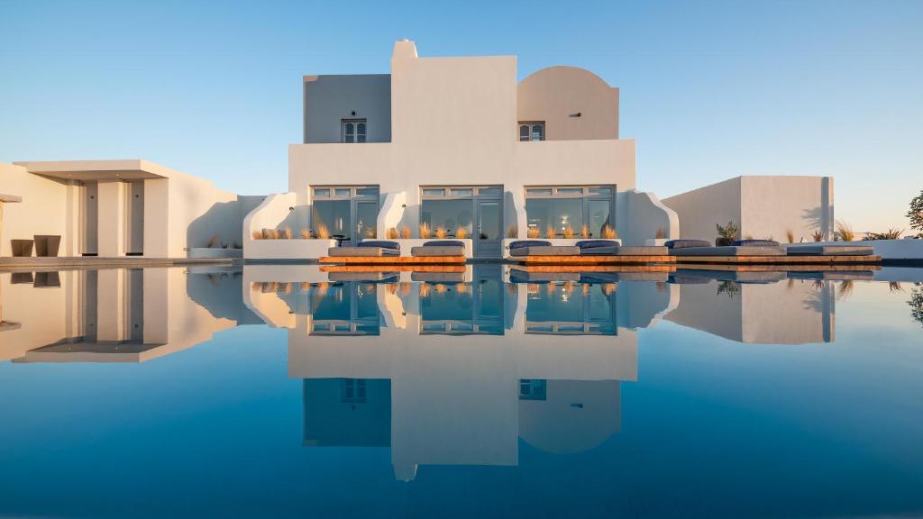a building with a pool of water in front of it at Volcanic Arc Suites in Oia