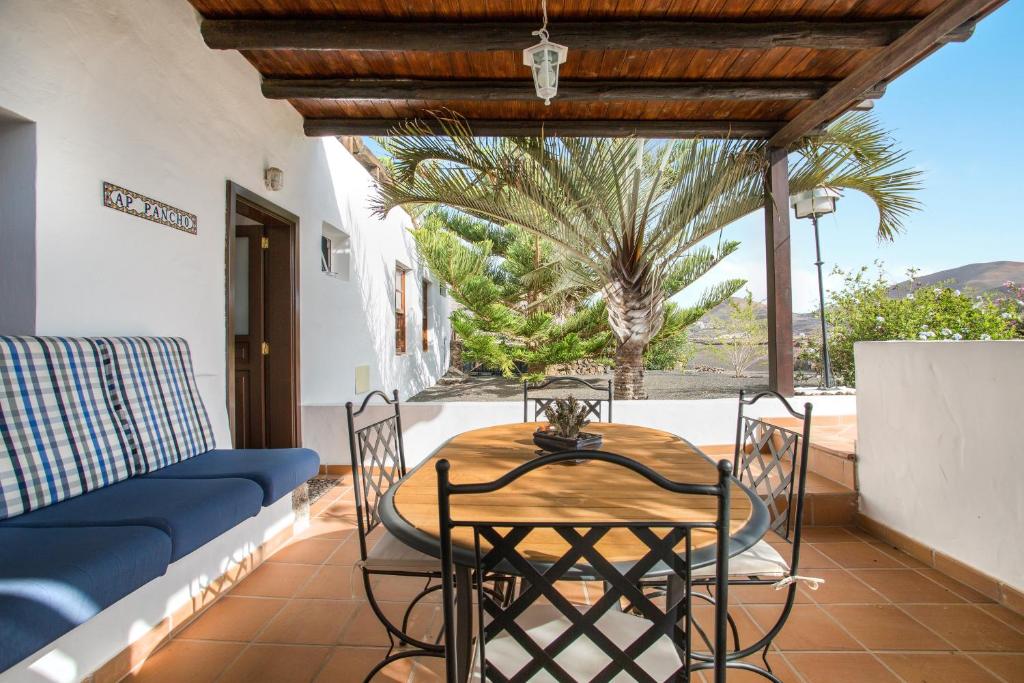 d'une terrasse avec une table, des chaises et un canapé. dans l'établissement Apartamento Pancho, à La Vegueta