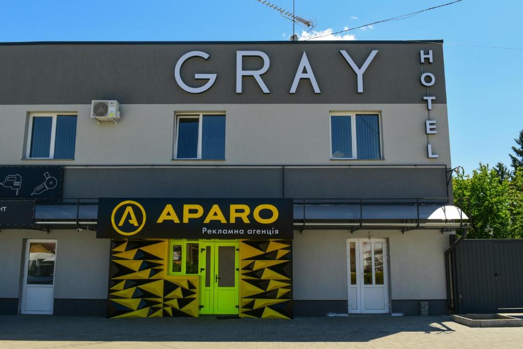 un bâtiment avec une porte verte et un panneau sur celui-ci dans l'établissement Gray Hotel, à Vynohradiv