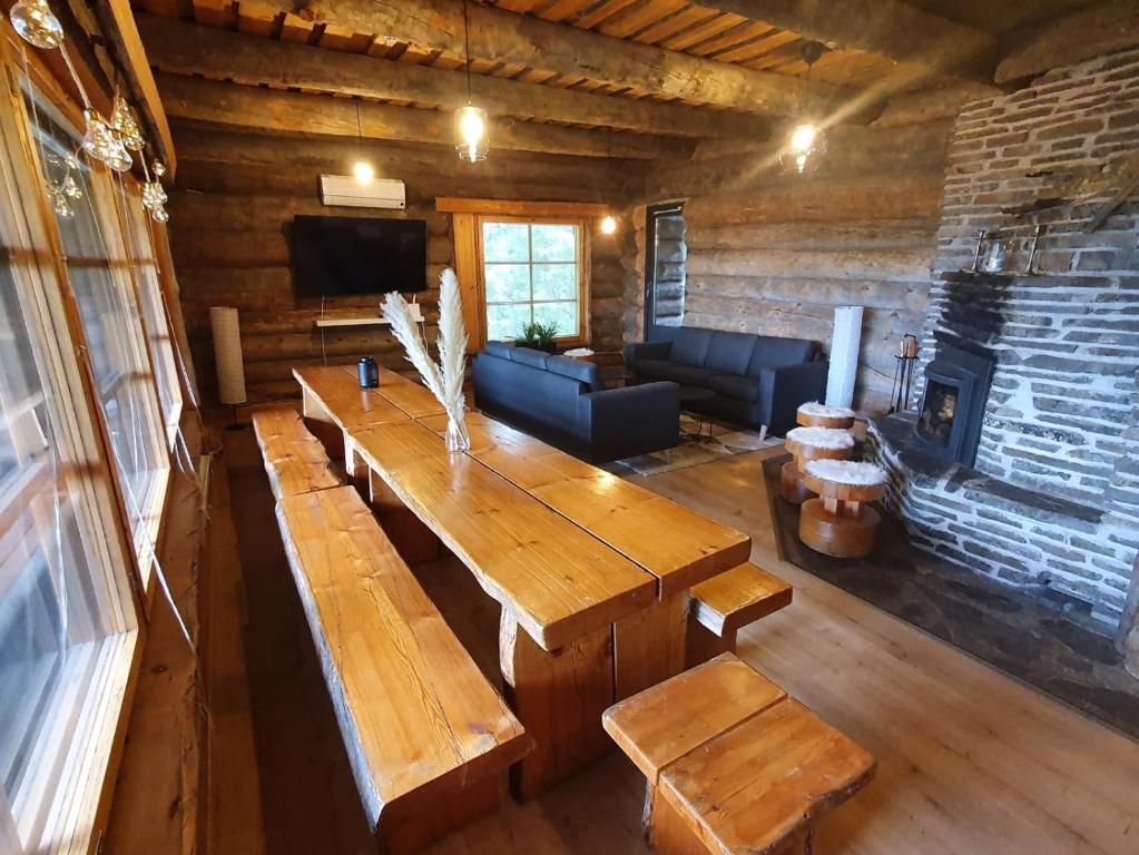 a living room with wooden tables and a fireplace at Riihitulkku Lodge in Muurame