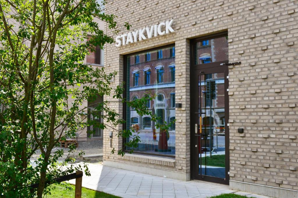 a shop with a sign on the front of a brick building at Staykvick Boutique Hostel in Helsingborg