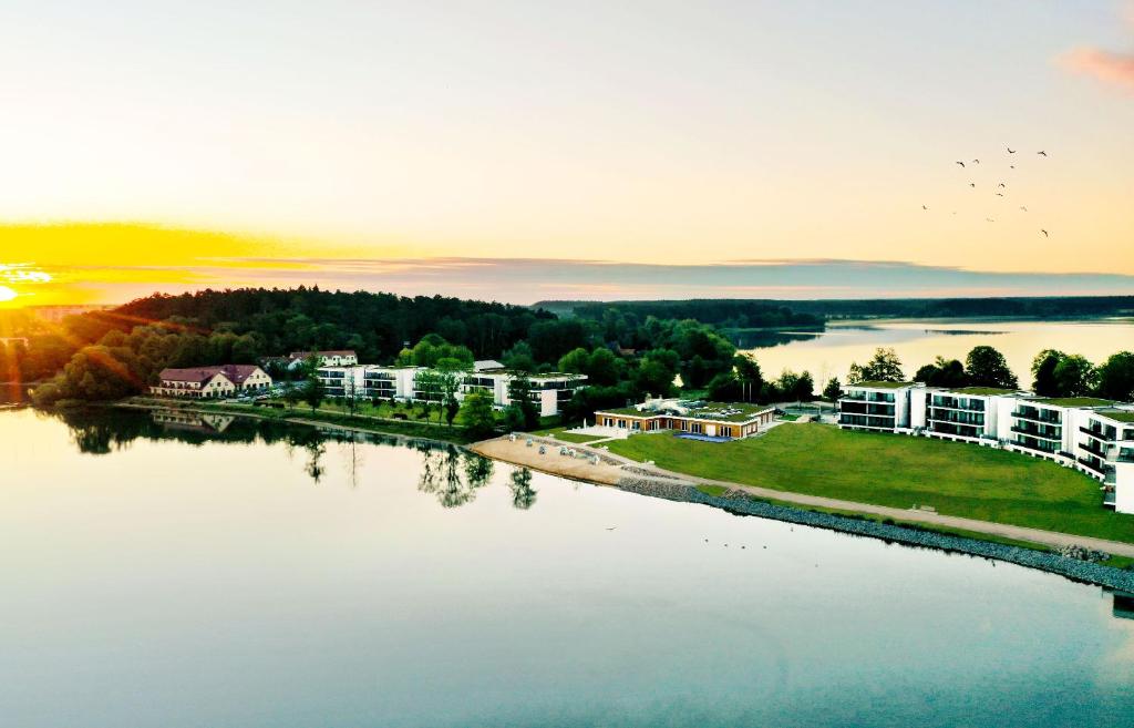una vista aerea di un resort sull'acqua al tramonto di Maremüritz Yachthafen Resort a Waren