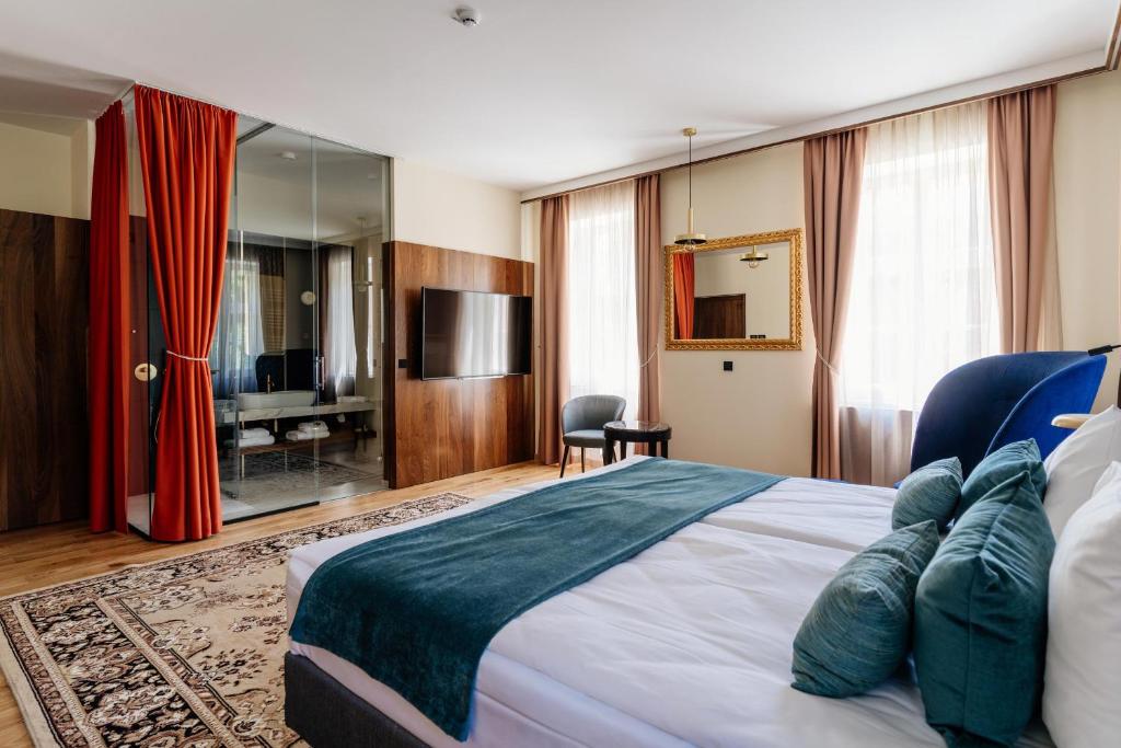 Habitación de hotel con cama y TV en Boutique Hotel Dobrna - Terme Dobrna, en Dobrna