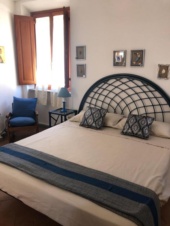 una camera con un grande letto e una sedia blu di STANZA INDIPENDENTE SUPER ARREDATA CENTRALE E LUMINOSISSIMA a Rio nellʼElba