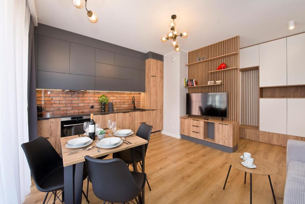 uma cozinha e sala de jantar com mesa e cadeiras em YOURAPART Rajska City Centre em Gdansk