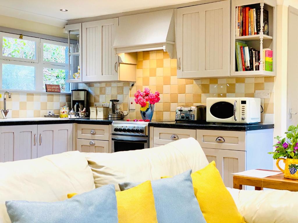 uma cozinha com um sofá branco numa cozinha em Amber Lodge Hickstead-A em Burgess Hill