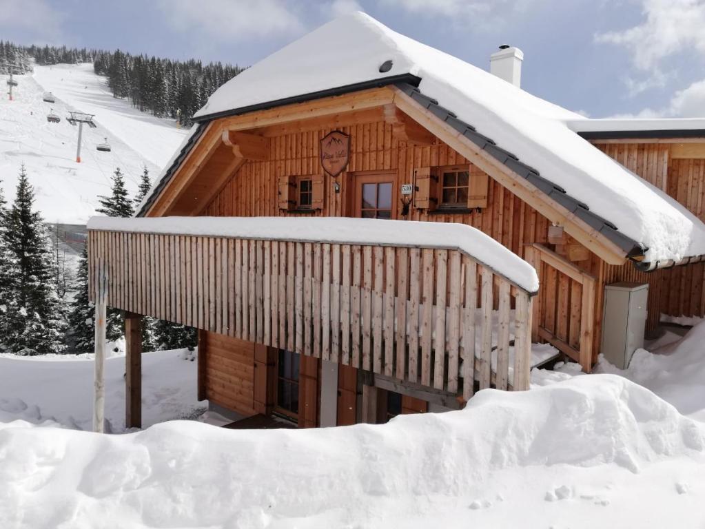 Cabaña de madera con techo cubierto de nieve en Chalet Risus Vallis Lachtal, en Lachtal