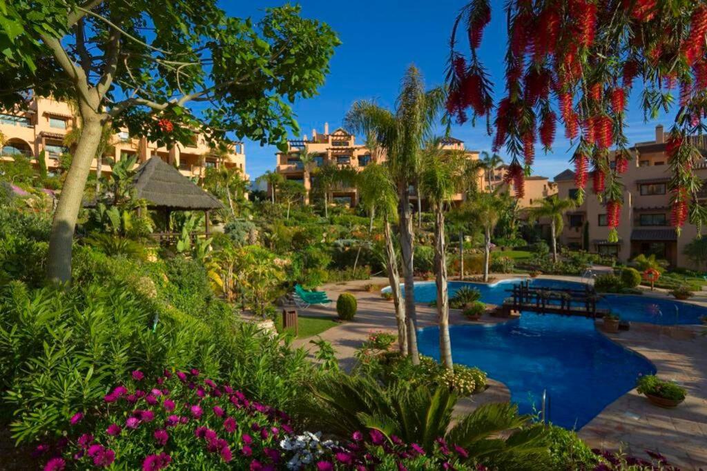 uma vista para um resort com uma piscina e flores em Marbella Luxury Fast Internet Netflix em Estepona