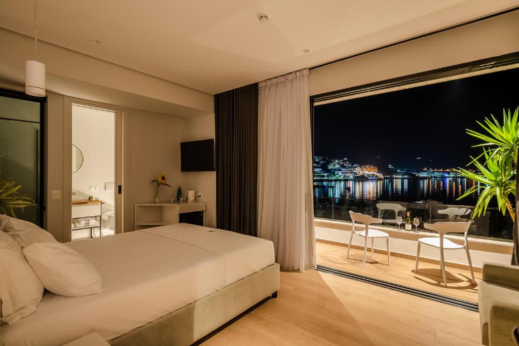 ein Schlafzimmer mit einem Bett und einem großen Fenster in der Unterkunft Rea Boutique Hotel in Himarë