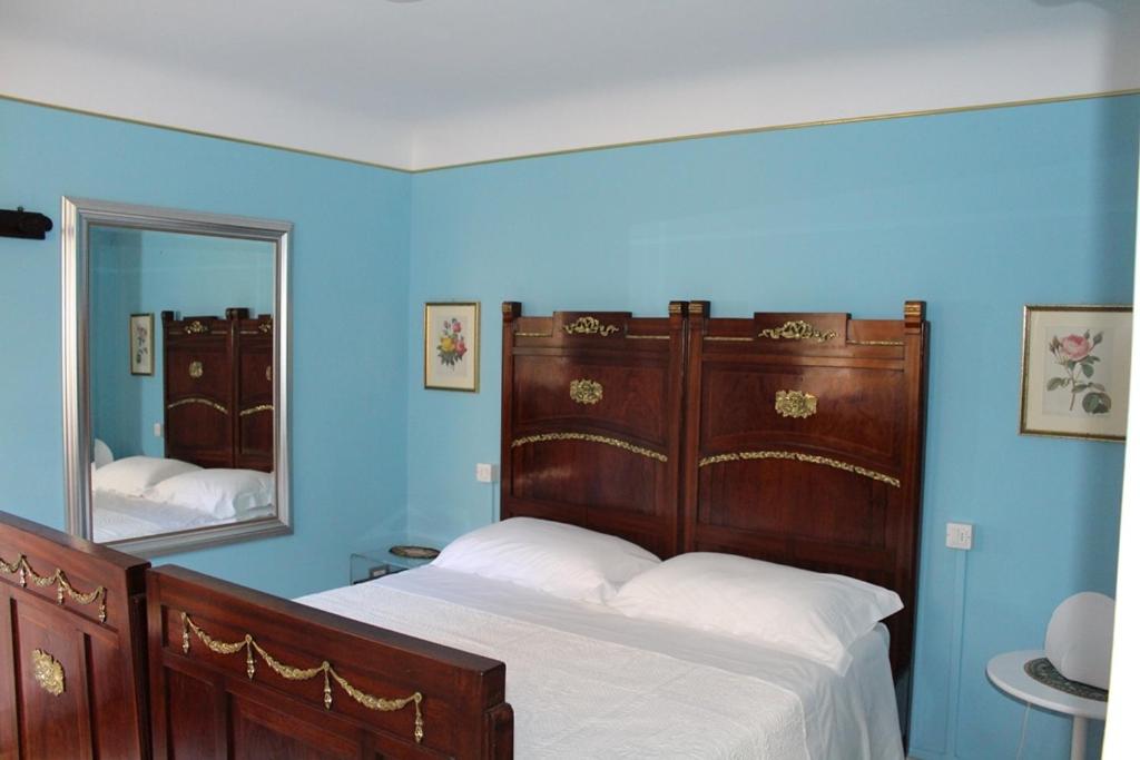B&B Porta Santa Lucia - Appartamento في فيرمو: غرفة نوم زرقاء مع سرير ومرآة