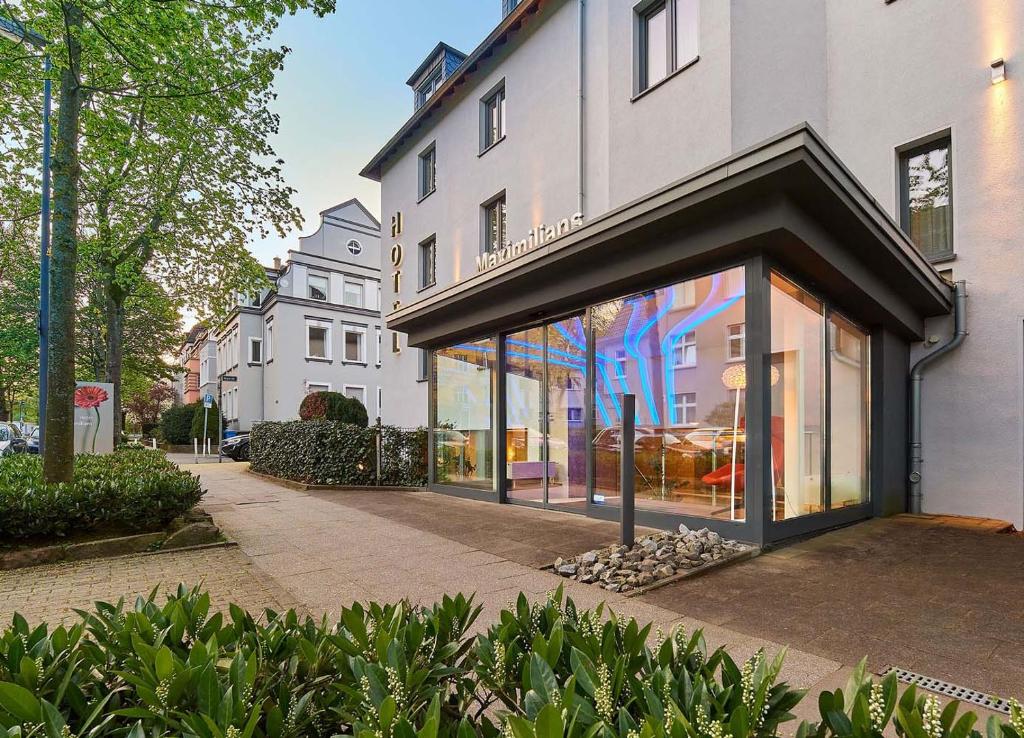 ein Gebäude mit Glasfenstern auf einer Stadtstraße in der Unterkunft Hotel Maximilians in Essen