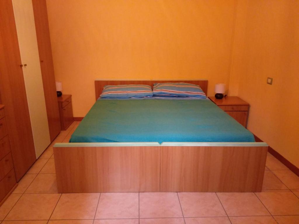 a bed with a wooden frame in a room at Lovere Lake Apartment in Lovere