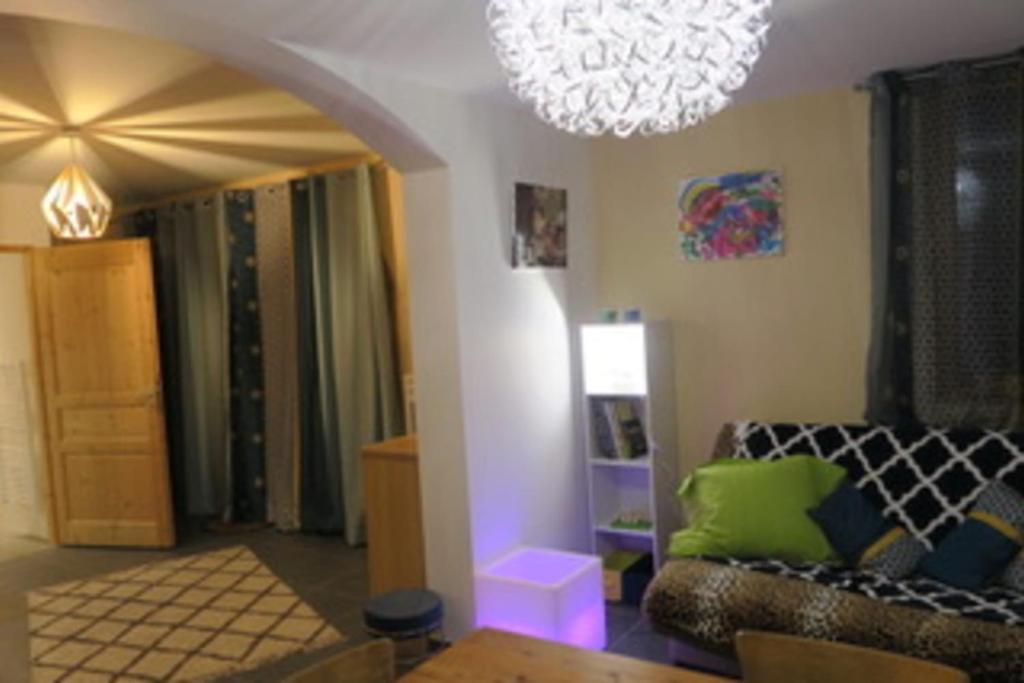 a living room with a couch and a chandelier at Gîte le Rocher - Suitable for people with reduced mobility in La Grave