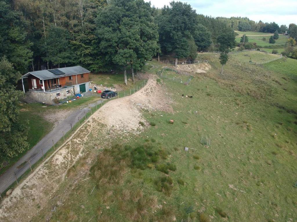une vue aérienne sur une maison dans un champ dans l'établissement Chalet du dry la roche., à Vielsalm