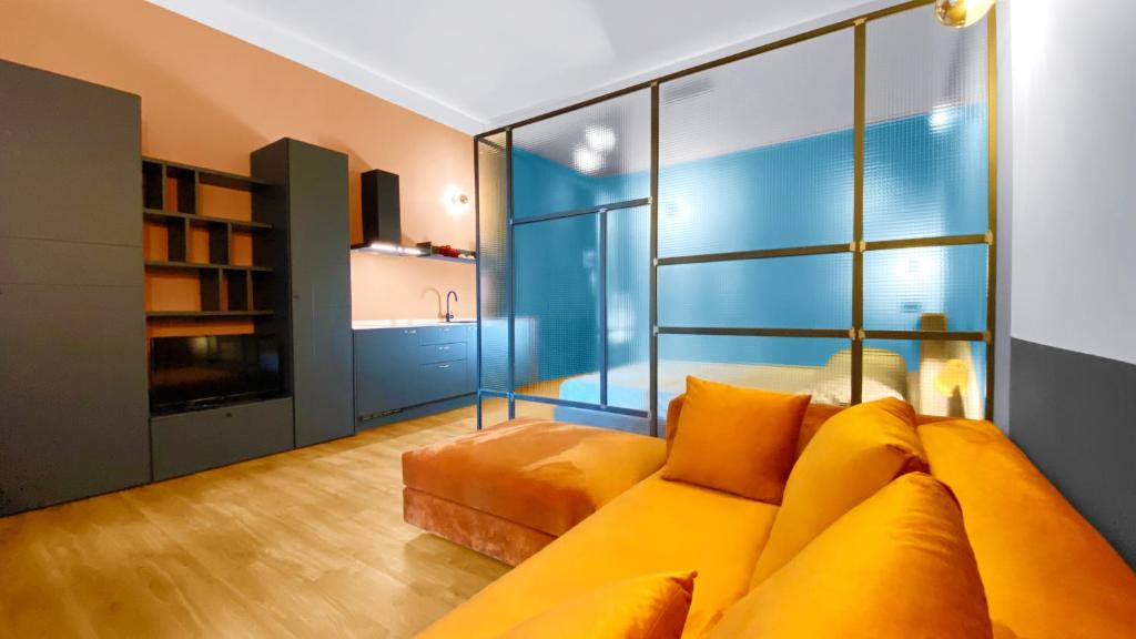 uma sala de estar com um sofá amarelo e uma cozinha em BNB Capital Milano Central Station - Blue em Milão