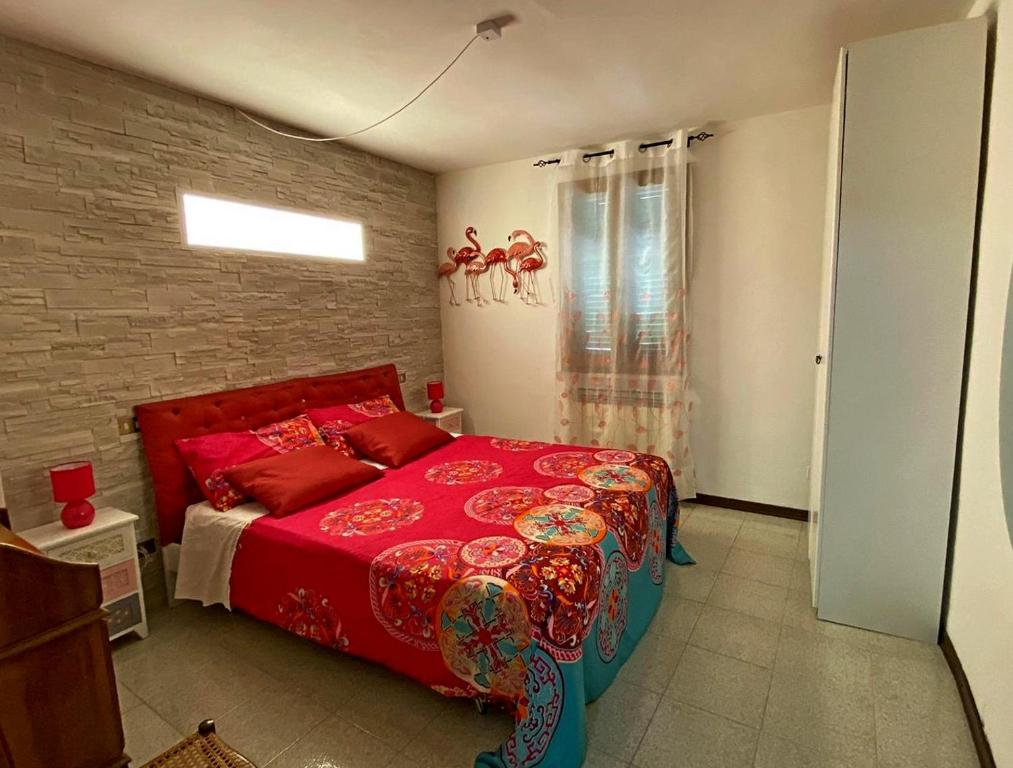 a bedroom with a red bed and a brick wall at La casa colorata in Città di Castello