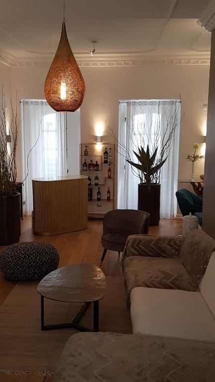 a living room with a couch and chairs and a lamp at Villa Zawaia B&B in Lagos