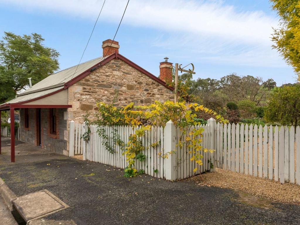 an old stone house with a white fence at Fig Tree Cottage in Angaston