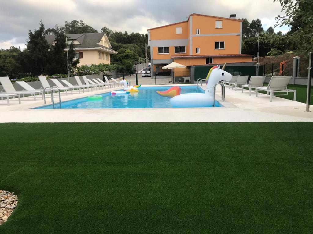 une piscine avec un canard gonflable au milieu dans l'établissement Pensión CHE, à O Pedrouzo
