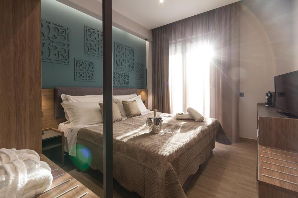 a hotel room with a bed and a television at Giafra Luxury Rooms in Agrigento