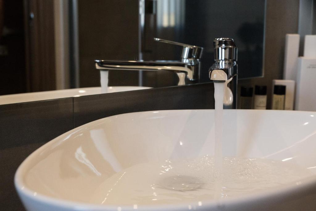 a white sink with a faucet in a bathroom at Giafra Luxury Rooms in Agrigento