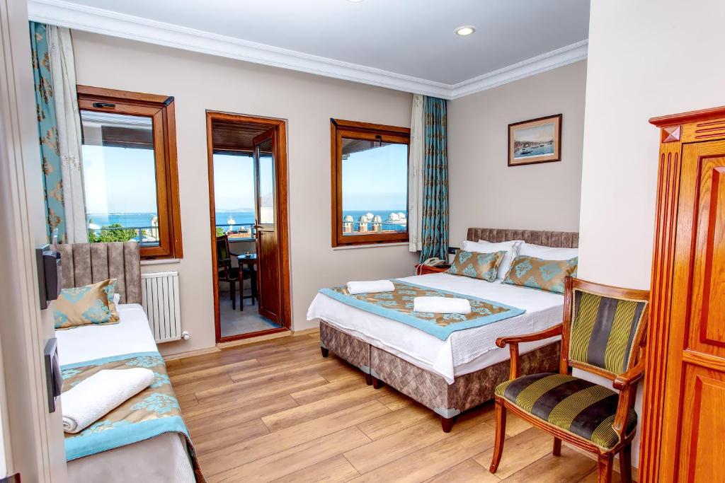Un dormitorio con una cama y una silla y ventanas. en Hotel Saba, en Estambul