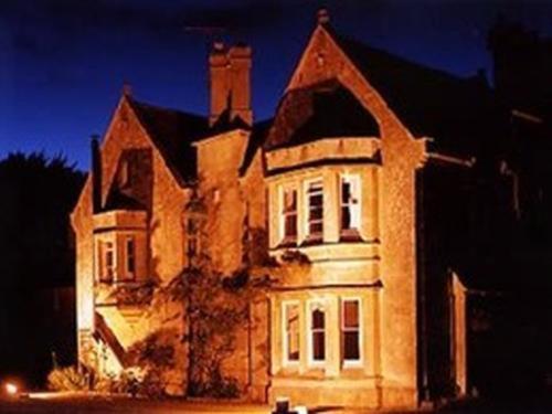 un gran edificio de ladrillo con una luz brillante en él en Burcombe Manor, en Barford Saint Martin