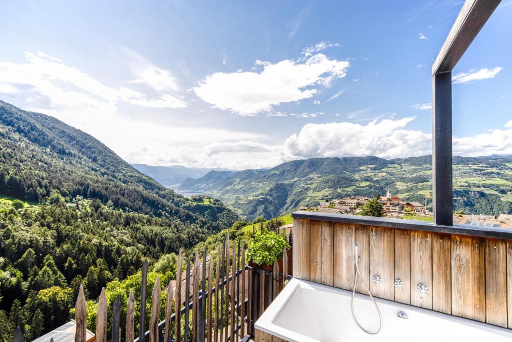 d'une baignoire sur le balcon avec vue sur les montagnes. dans l'établissement Sonnleiten Sterngucker 10, à Collepietra