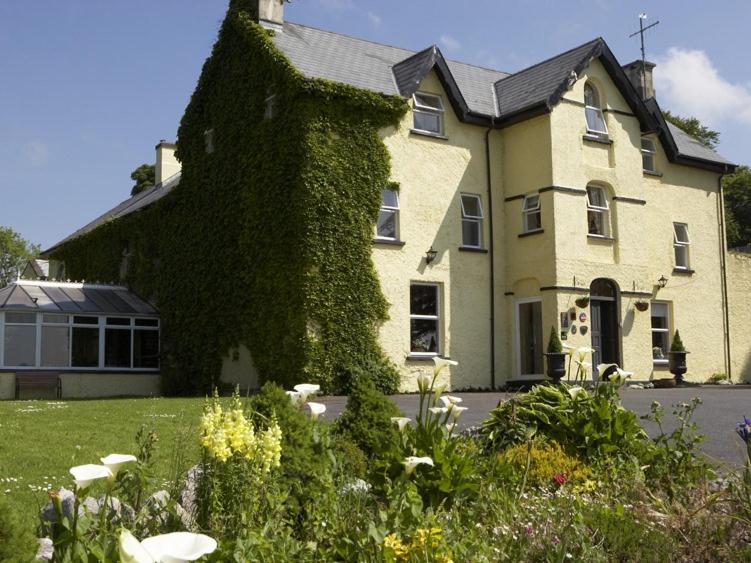 a house with ivy growing on the side of it at Carrygerry Country House in Shannon