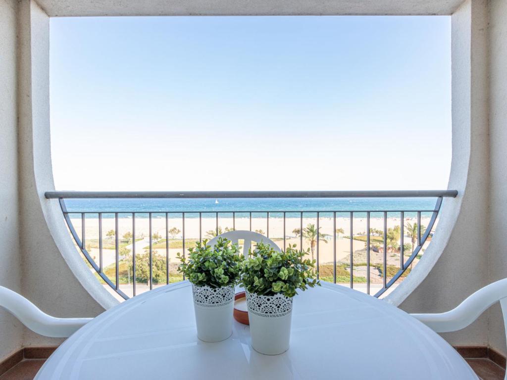 dos plantas en una mesa blanca delante de una ventana en Apartment Bahia I by Interhome, en Empuriabrava