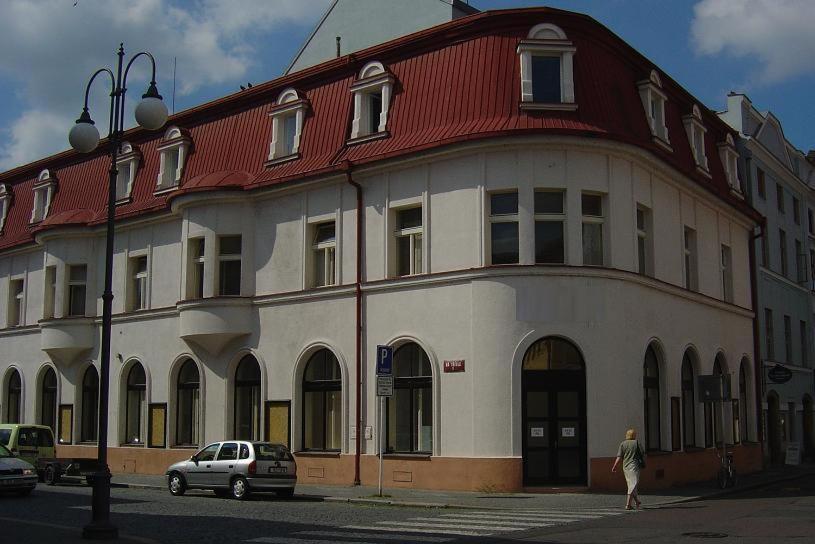 un gran edificio blanco con techo rojo en Hotel Mrázek en Pardubice