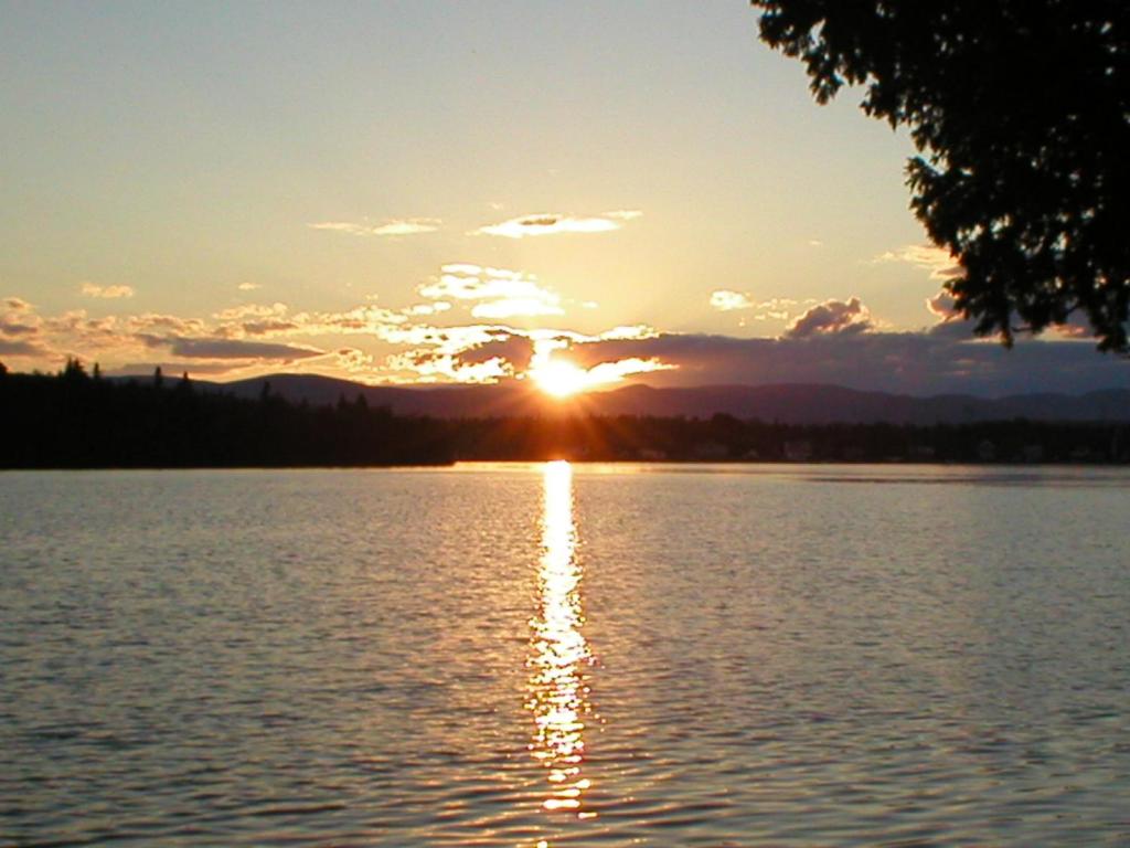 a sunset over a large body of water at Le Chalet Relax du Lac St-Tite in Saint-Tite-des-Caps