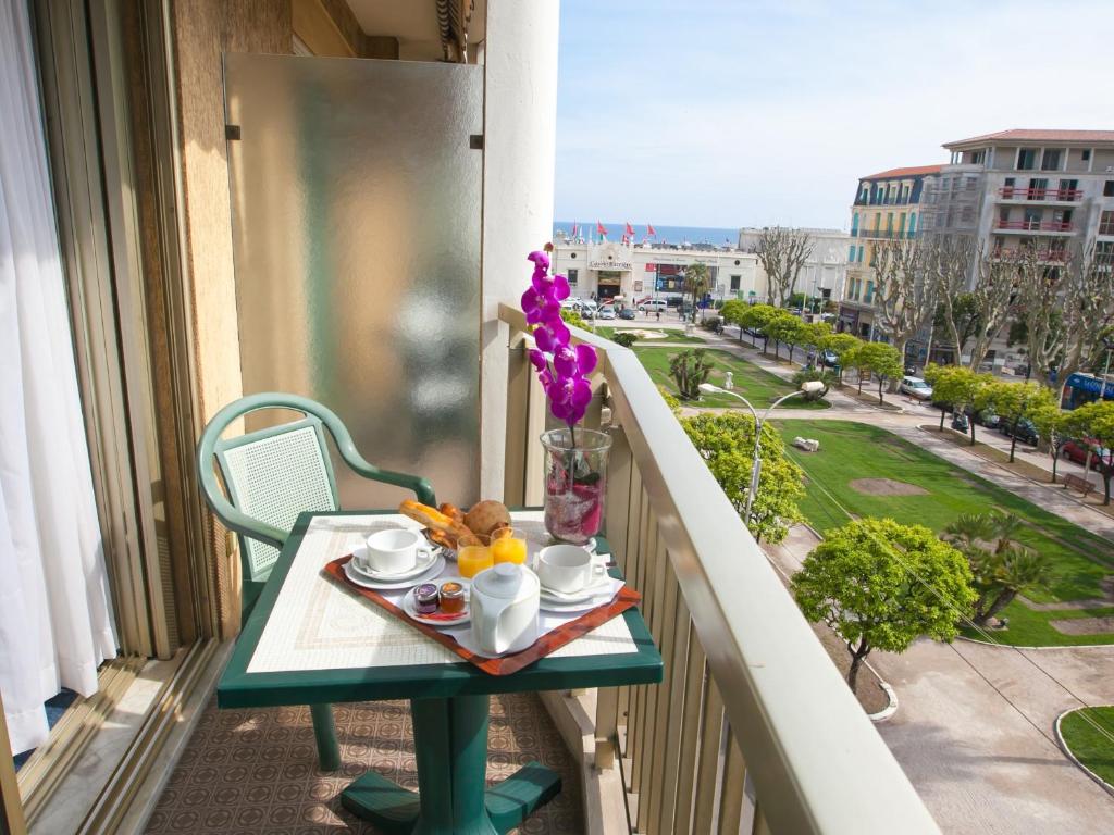 a table with a tray of food on a balcony at Hotel Chambord in Menton