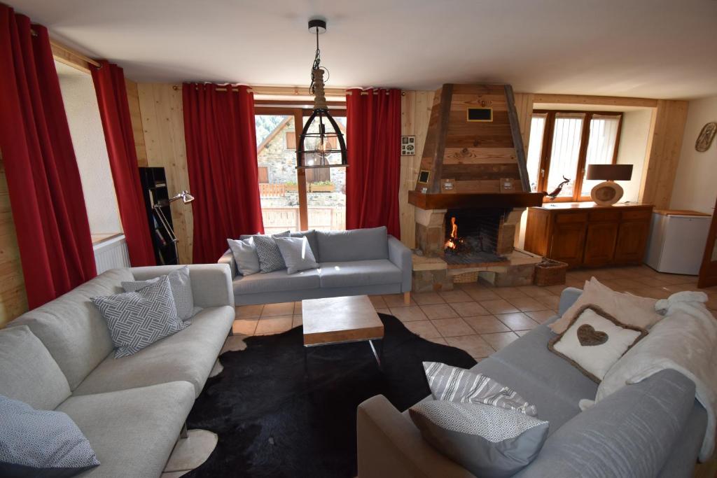 sala de estar con 2 sofás y chimenea en VAUJANYLOCATIONS - Chalet Louise, en Vaujany